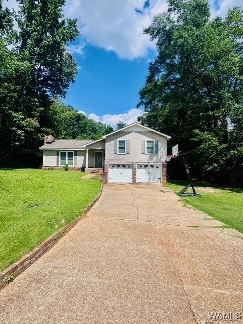 split level home featuring an attached garage, concrete driveway, a front lawn, and brick siding