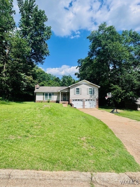 tri-level home with a garage, driveway, and a front lawn