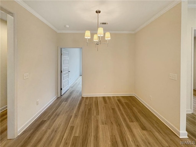 unfurnished dining area with an inviting chandelier, hardwood / wood-style floors, and crown molding