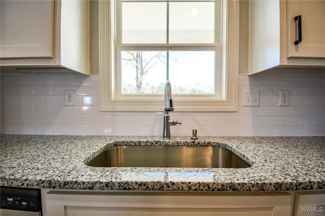 room details with sink, decorative backsplash, dishwasher, and light stone countertops