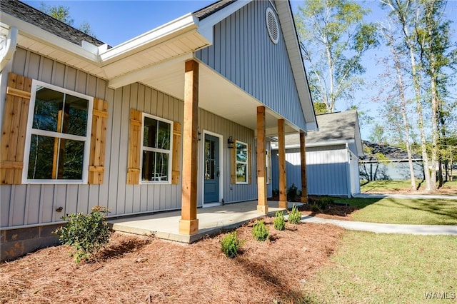 rear view of property with covered porch and a yard