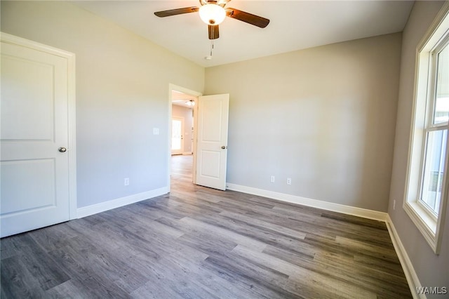 unfurnished bedroom featuring ceiling fan and dark hardwood / wood-style flooring