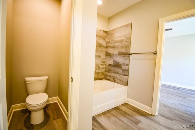 bathroom featuring bathing tub / shower combination, toilet, and wood-type flooring