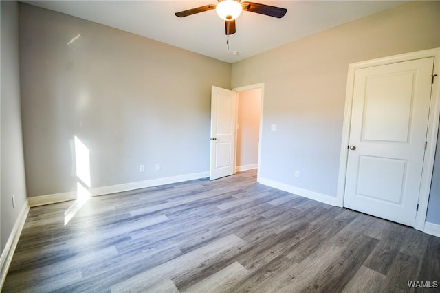 empty room with ceiling fan and wood-type flooring