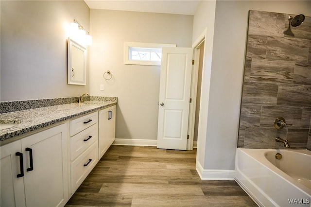 bathroom featuring washtub / shower combination, vanity, and wood-type flooring