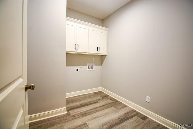 laundry area with electric dryer hookup, hookup for a washing machine, cabinets, and wood-type flooring