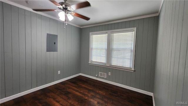 empty room featuring electric panel, wooden walls, dark hardwood / wood-style floors, ceiling fan, and ornamental molding