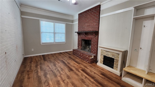 unfurnished living room featuring ornamental molding, dark wood-type flooring, and a brick fireplace