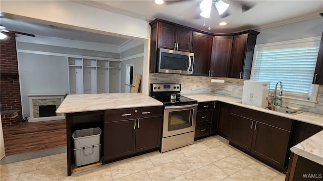 kitchen featuring appliances with stainless steel finishes, ceiling fan, crown molding, and sink