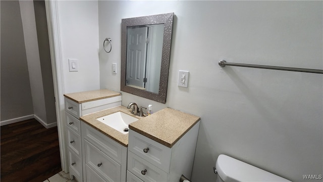 bathroom with vanity, toilet, and wood-type flooring