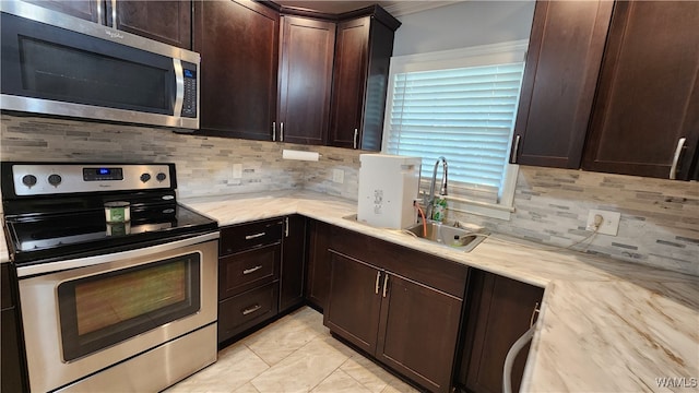 kitchen with decorative backsplash, sink, dark brown cabinets, and appliances with stainless steel finishes