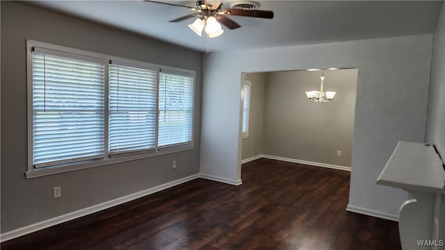 spare room with dark hardwood / wood-style floors and ceiling fan with notable chandelier