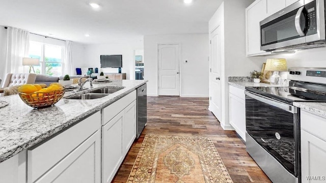 kitchen with sink, dark hardwood / wood-style floors, light stone counters, white cabinetry, and stainless steel appliances