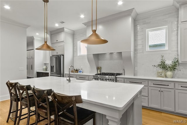 5377 Alexander Ave, Tuscaloosa, AL 35406 - kitchen featuring stainless steel refrigerator with ice dispenser, light wood-type flooring, light countertops, a kitchen island with sink, and recessed lighting