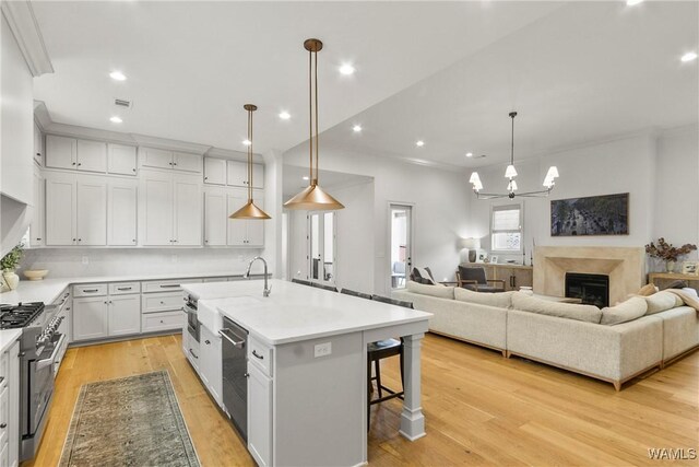 5377 Alexander Ave, Tuscaloosa, AL 35406 - kitchen featuring stainless steel appliances, a chandelier, a kitchen bar, light countertops, and a center island with sink