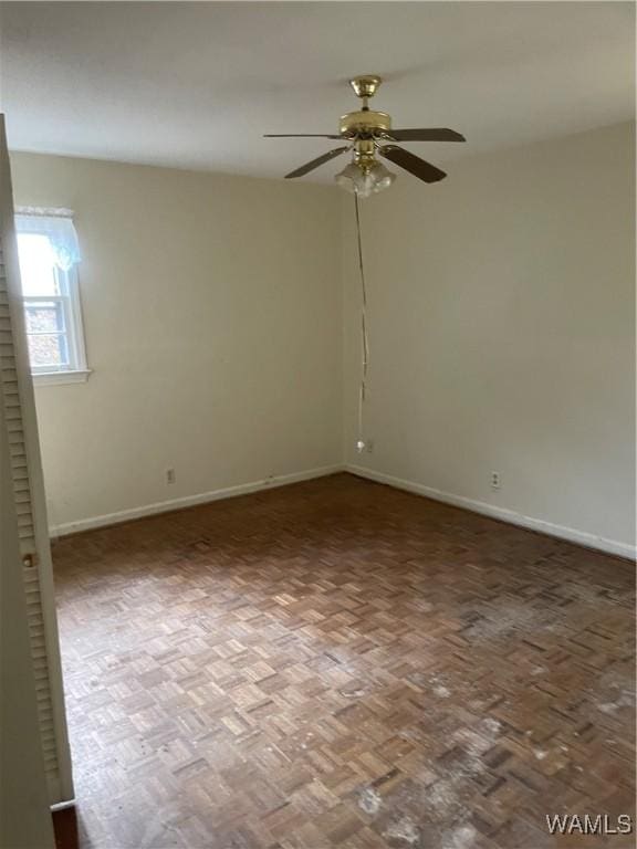 unfurnished room featuring ceiling fan and parquet flooring