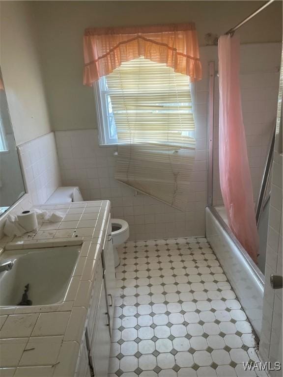 full bathroom featuring shower / bathtub combination with curtain, vanity, tile walls, and toilet