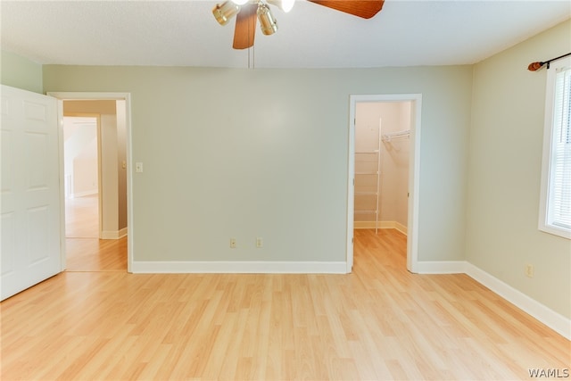 spare room featuring ceiling fan, light wood-type flooring, and a wealth of natural light