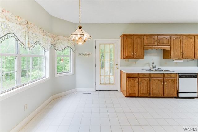 kitchen featuring white dishwasher, a notable chandelier, pendant lighting, and sink