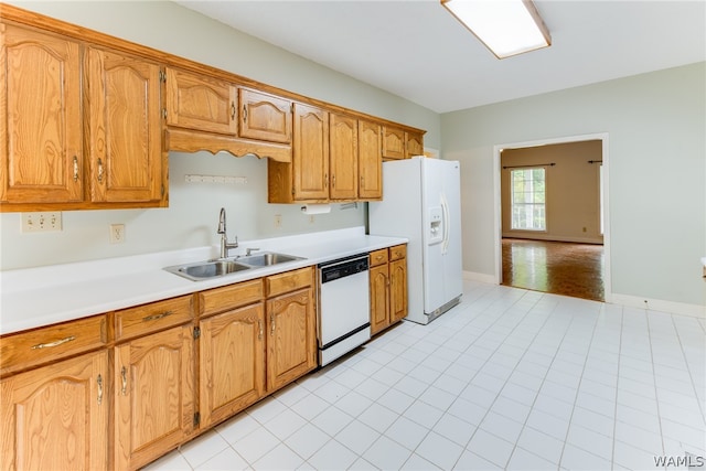 kitchen with light tile patterned floors, white appliances, and sink