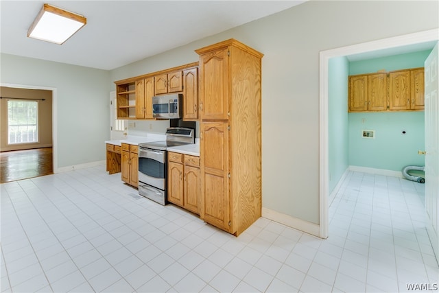 kitchen with light tile patterned flooring and appliances with stainless steel finishes