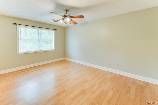 empty room featuring ceiling fan, light hardwood / wood-style floors, and a textured ceiling