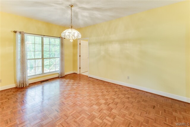 unfurnished room featuring an inviting chandelier and parquet floors