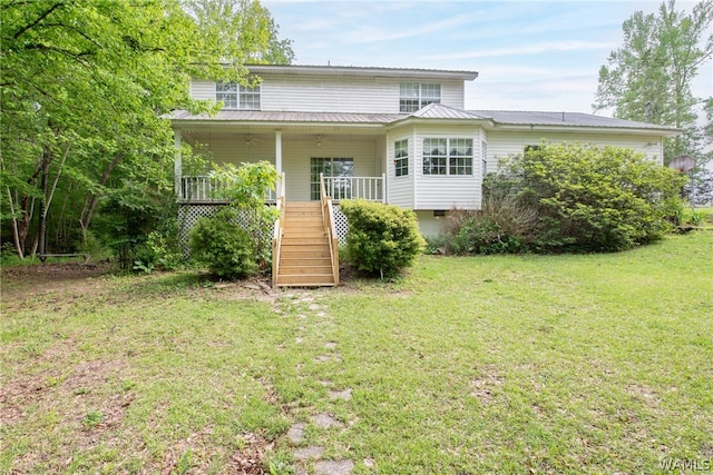 back of house with a lawn and covered porch