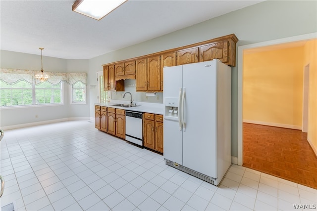 kitchen with sink, an inviting chandelier, light parquet floors, decorative light fixtures, and white appliances