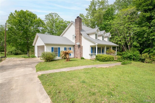 view of front of property with a front lawn, covered porch, and a garage