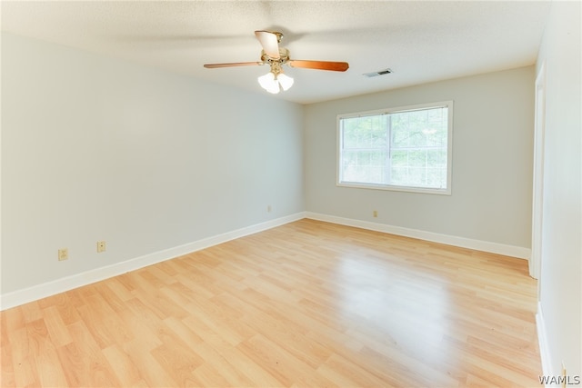 unfurnished room featuring ceiling fan, light hardwood / wood-style floors, and a textured ceiling