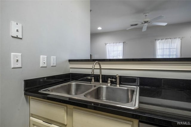 kitchen featuring dark countertops, a sink, visible vents, and a healthy amount of sunlight