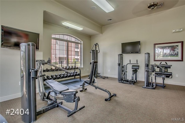 exercise room with ornamental molding, visible vents, and baseboards