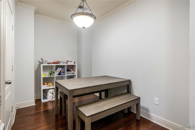 dining space featuring baseboards, wood finished floors, and crown molding