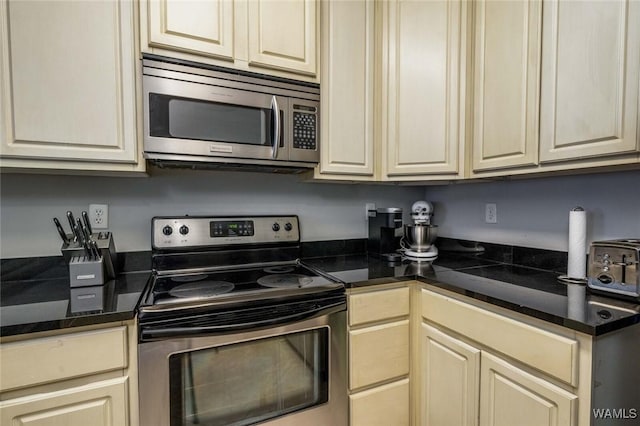 kitchen featuring stainless steel appliances and cream cabinetry