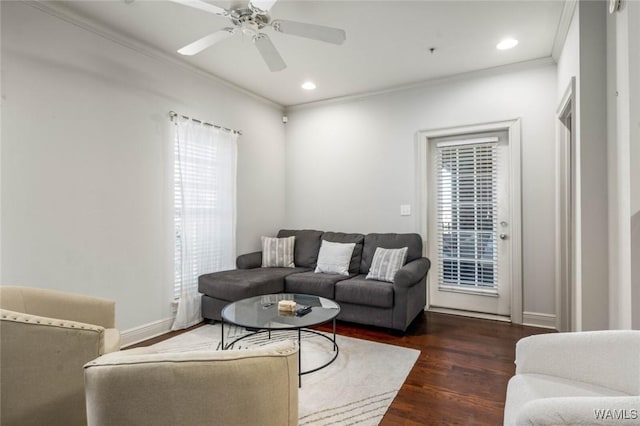 living room with a wealth of natural light, crown molding, and wood finished floors