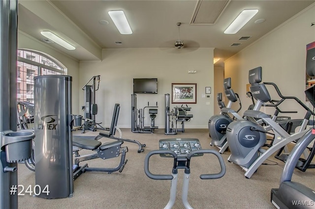 exercise room featuring attic access, visible vents, crown molding, and baseboards