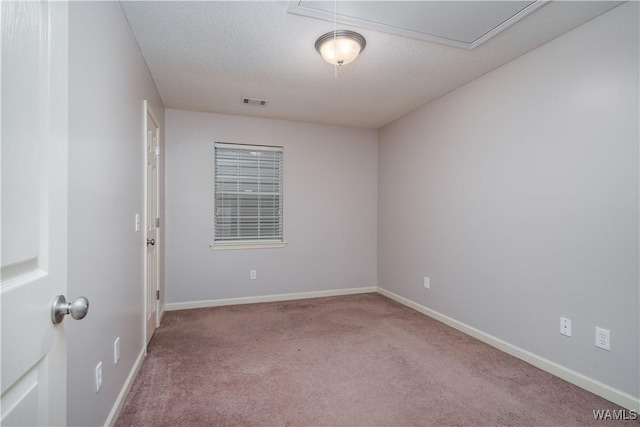 unfurnished room featuring light carpet and a textured ceiling