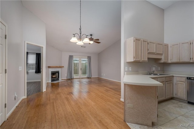 kitchen with pendant lighting, sink, dishwasher, high vaulted ceiling, and kitchen peninsula