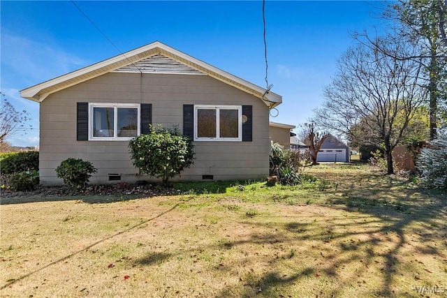 view of side of home with crawl space and a yard