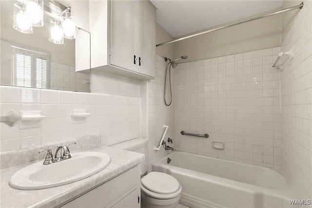 bathroom with tile walls, toilet, bathtub / shower combination, vanity, and backsplash