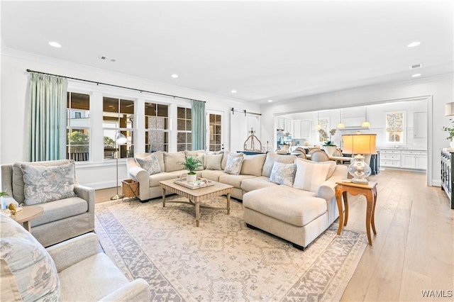 living area featuring ornamental molding, light wood finished floors, visible vents, and recessed lighting