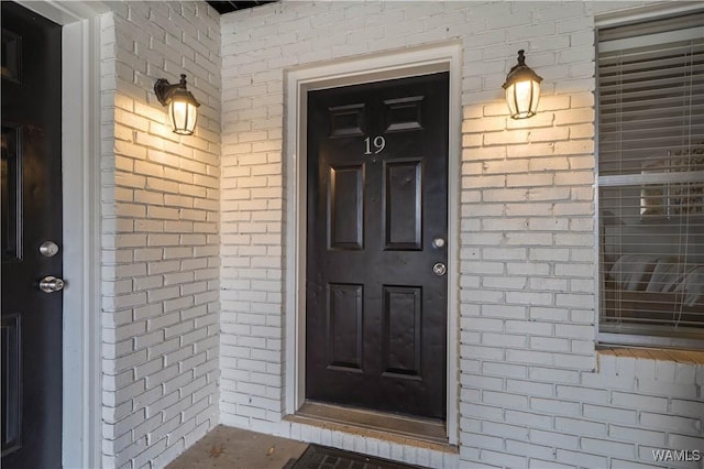 entrance to property featuring brick siding