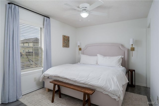 bedroom featuring ceiling fan, baseboards, and wood finished floors