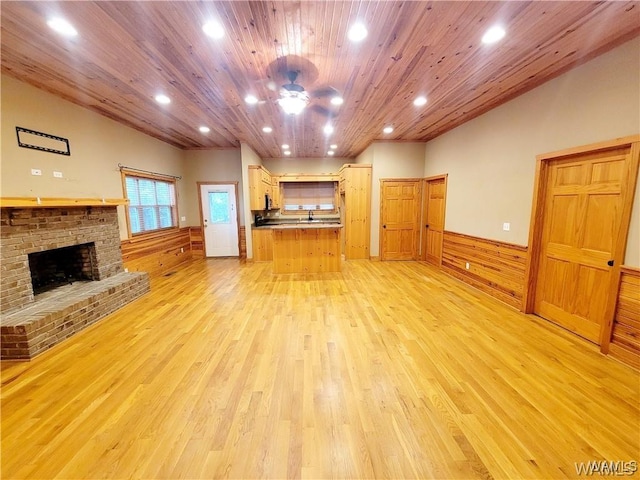 unfurnished living room with light wood-style floors, recessed lighting, wooden ceiling, and a wainscoted wall