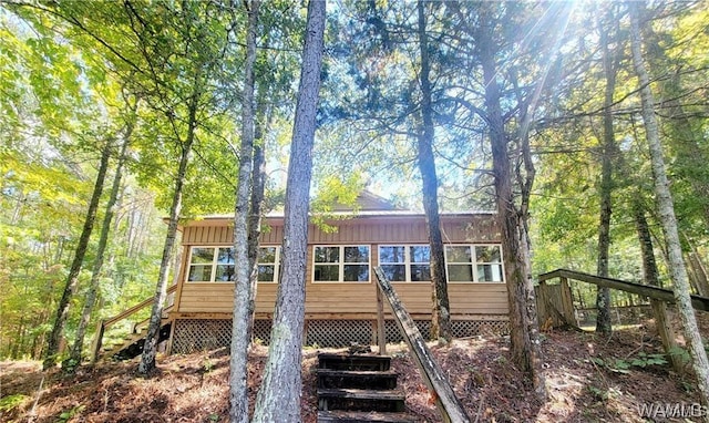 view of front of property featuring a sunroom, stairway, and board and batten siding