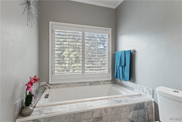 bathroom featuring toilet, ornamental molding, a wealth of natural light, and tiled bath