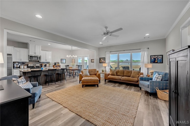13930 Sullivan Blvd, Northport, AL 35475 - living room with crown molding, light wood-style flooring, recessed lighting, and ceiling fan with notable chandelier