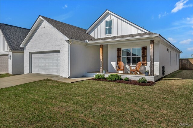 13930 Sullivan Blvd, Northport, AL 35475 - modern farmhouse with concrete driveway, board and batten siding, a front lawn, a garage, and covered porch