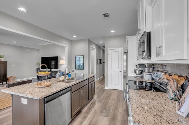 13930 Sullivan Blvd, Northport, AL 35475 - kitchen with an island with sink, white cabinetry, visible vents, a sink, and stainless steel appliances